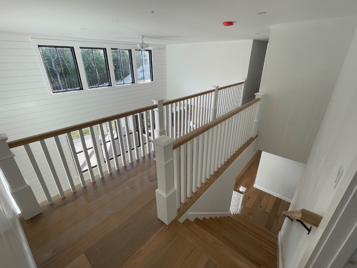 Custom staircase with white balusters and oak handrail